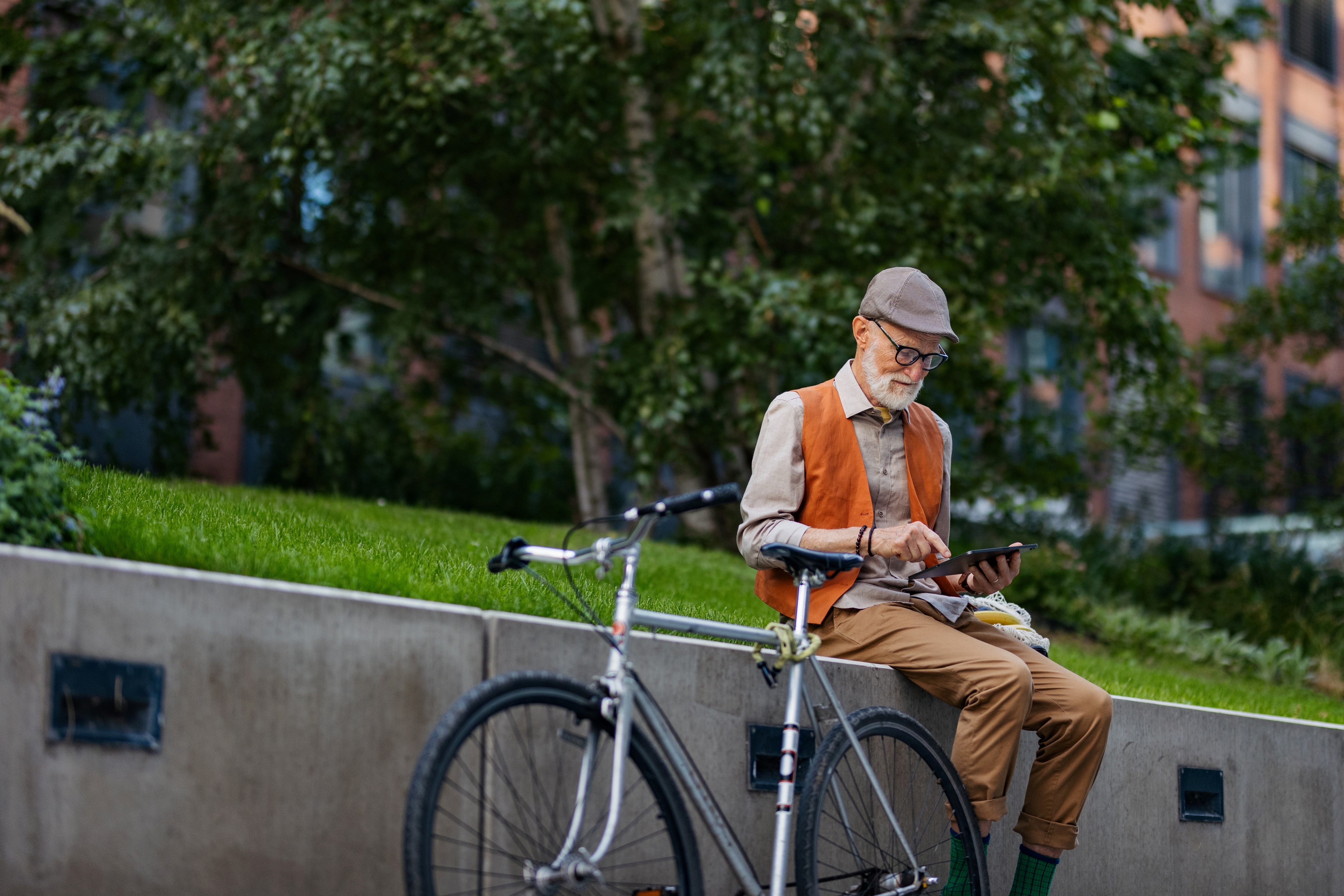 Older man using a tablet device outdoors